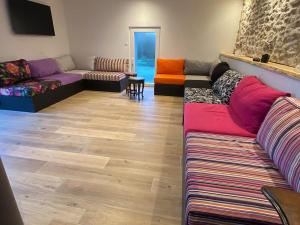 a living room with colorful couches and a wooden floor at L'Opale des Tribus in Audresselles