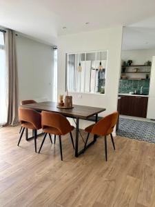 a dining room table and chairs in a living room at La longère Cosy & Centrale in Bétheny
