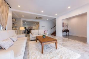 a living room with a white couch and a coffee table at Luxury Bungalow TTDI, 16-22pax, Swimming Pool, One Utama in Kuala Lumpur