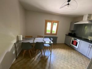 a kitchen with a table and chairs in a room at Gîte de charme dans la vallée du Borne au cœur des Alpes in Glières-Val-de-Borne