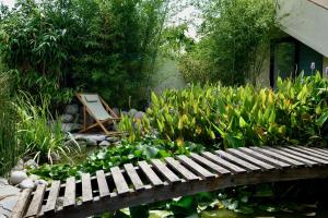 a wooden bench in a garden with a chair at Torre Costa Brava Private pool in Garrigás