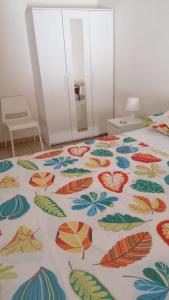 Una cama con una manta colorida con hojas. en Casa Santiago 2, en Gela
