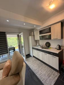 a kitchen with a couch and a kitchen with a sink at Apartmani Vanilla in Zavidovići