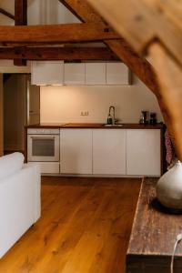 eine offene Küche mit weißen Schränken in einem Loft in der Unterkunft Landgoed Frymerson in Sint Odiliënberg + 14 Fotos