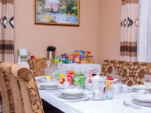 a dining room table with a white table cloth and chairs at Fanham Homes in Bulawayo