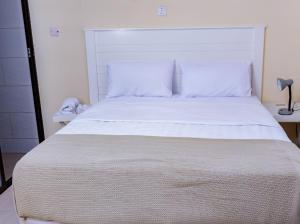 a bedroom with a large white bed in a room at Fanham Homes in Bulawayo