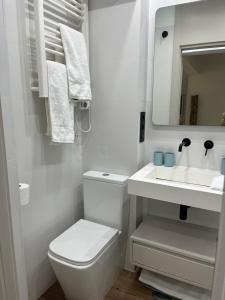 a white bathroom with a toilet and a sink at Marbella-abc-aparts in Marbella