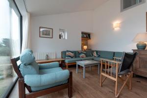 un salon avec un canapé bleu et des chaises dans l'établissement Belle Familiale Au Bord De La Mer, à l'Île-aux-Moines