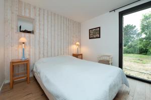 une chambre avec un lit et une grande fenêtre dans l'établissement Belle Familiale Au Bord De La Mer, à l'Île-aux-Moines