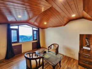 a living room with a table and chairs and a window at Florence B&B Near Mall Road - Amazing Valley View in Shimla