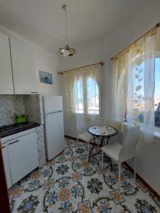 a kitchen with a small table and a refrigerator at Appartamenti Iacono in Forio d'Ischia