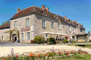 a large stone building with flowers in front of it at Logis Hôtel Le Relais Louis XI in Meung-sur-Loire