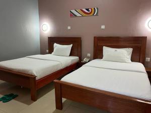 2 Betten in einem Hotelzimmer mit 2 Betten sidx sidx sidx sidx in der Unterkunft REBERO RESORT Ltd in Kigali + 37 Fotos