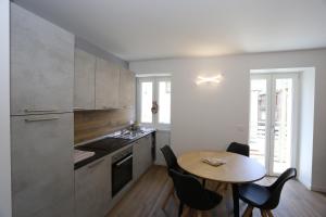 Casa BEA 2 في كاستوني ديلا بريسولانا: مطبخ مع طاولة خشبية وطاولة وكراسي صغيرة