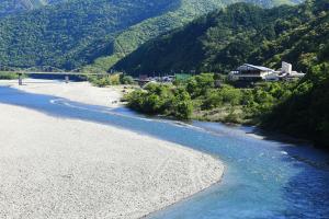 une vue sur une rivière avec un pont en arrière-plan dans l'établissement Iruka Onsen Hotel Seiryuusou, à Kumano