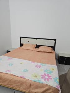a bedroom with a large bed with flowers on it at Casa blu ghar el melh in Île Pilau