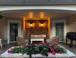 a patio with a couch and a table and flowers at Sosenkowe Apartamenty Balia & Jacuzzi in Kuźnica Głogowska