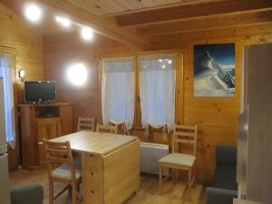a dining room with a wooden table and chairs at Les Chalets in Les Prats