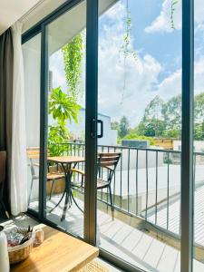 a balcony with sliding glass doors with a table and a view at 308MSNK Maison Luxe Studio l Balcony & Kitchen in Can Tho