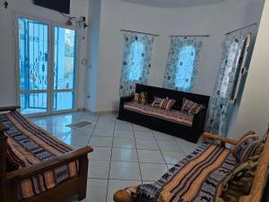 a room with two beds in a room with a window at Casa blu ghar el melh in Île Pilau