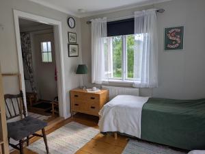 a bedroom with a bed and a chair and a window at Beautiful Idhult 2 in Aneby