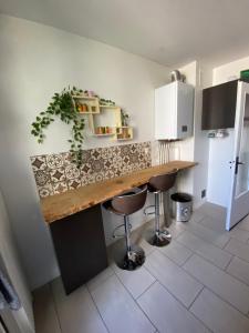 a kitchen with a counter and stools in a room at Appartement 2 chambres 5 pièces paisible in Villefranche-sur-Saône +5 photos