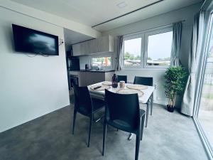 a kitchen and dining room with a table and chairs at Mobilheim 90 in Hüde
