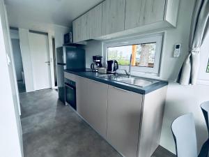 a small kitchen with a sink and a window at Mobilheim 90 in Hüde