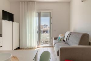 a living room with a couch and a view of a balcony at Palladio13 in San Benedetto del Tronto