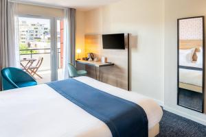 a hotel room with a bed and a balcony at Best Western Hotel Fontaine Argent in Besançon