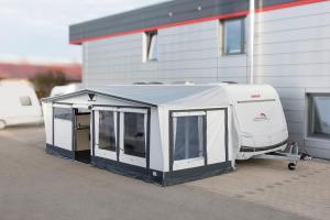 a white rv parked next to a building at Mietwohnwagen 54 in Hüde +2 photos