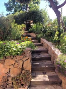 a garden path with flowers and a stone wall at Loc Provence - Rez-de-villa in Montauroux