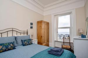 a bedroom with a blue bed and a window at Ocean View Apartment in Filey +11 photos