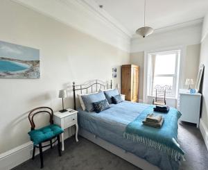 a bedroom with a blue bed and a chair at Ocean View Apartment in Filey