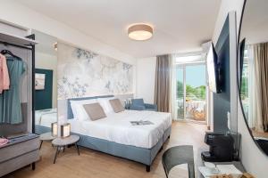 een slaapkamer met een bed en een tv in een kamer bij Hotel Bembo in Bibione +84 foto's