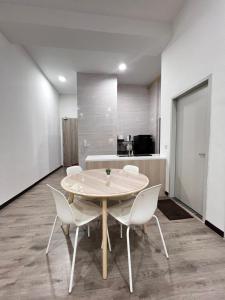 a dining room with a table and white chairs at The Executive 27 by MySky Putrajaya in Putrajaya