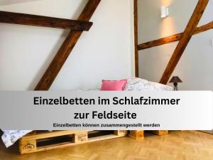 an attic room with a bed and a window at Gut Bisdorf Eixen - Mache Urlaub und werde Gutshausretter in Eixen
