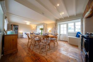 a kitchen and dining room with a table and chairs at Penrose Cottage in Bude