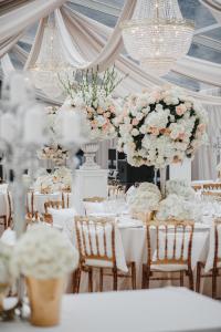 a wedding reception with white tables and chairs and flowers at FOREST PALANGA RESORT in Palanga