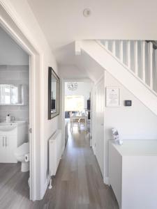 a white bathroom with a sink and a toilet at Hedgehog Cottage in Bury Saint Edmunds