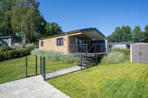 a tiny house in a yard with a fence at Ferienhaus "Ostseeperle" mit kostenfreier Saunanutzung, Grundstück Umzäunt in Scharbeutz