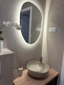 a bathroom with a white sink and a mirror at Apartman Eden in Sisak