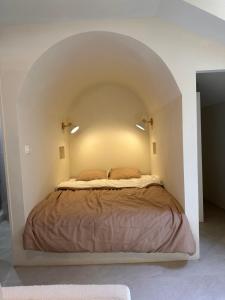 a bedroom with a bed in a white room at Studio Santorin in Périgueux