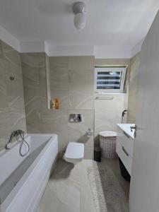 a bathroom with a tub and a toilet and a sink at Condo in Cluj-Napoca in Cluj-Napoca +4 photos