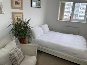 a bed in a room with a couch and a chair at Spacious, smart apartment near City Centre and Coop Arena Free parking in Manchester