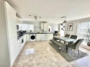 a kitchen with a table and a dining room at Spacious, smart apartment near City Centre and Coop Arena Free parking in Manchester