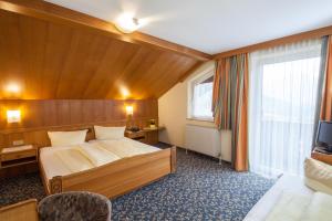 um quarto de hotel com uma cama e uma televisão em Kinderhotel Sailer em Wenns