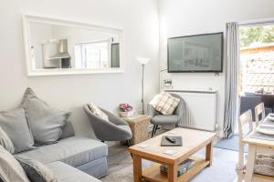 a living room with a couch and a table at Hedgehog Cottage in Bury Saint Edmunds