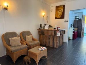 a room with two chairs and a table with a dog in it at Ardour Lodge "A" Wing in Tanjung Bungah