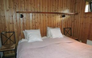 a bed with white pillows in a wooden wall at Naturskönt boende med tillgång till båt in Vrigstad